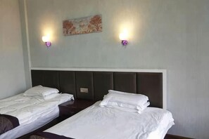 A hotel room with two single beds, a headboard, and two wall-mounted light fixtures. - Xianju Tianyuan Hotel (Xianju)