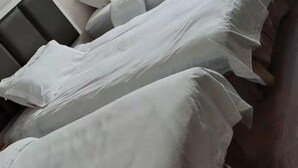 A bed with white linens and a dark headboard. - Xianju Tianyuan Hotel (Xianju)