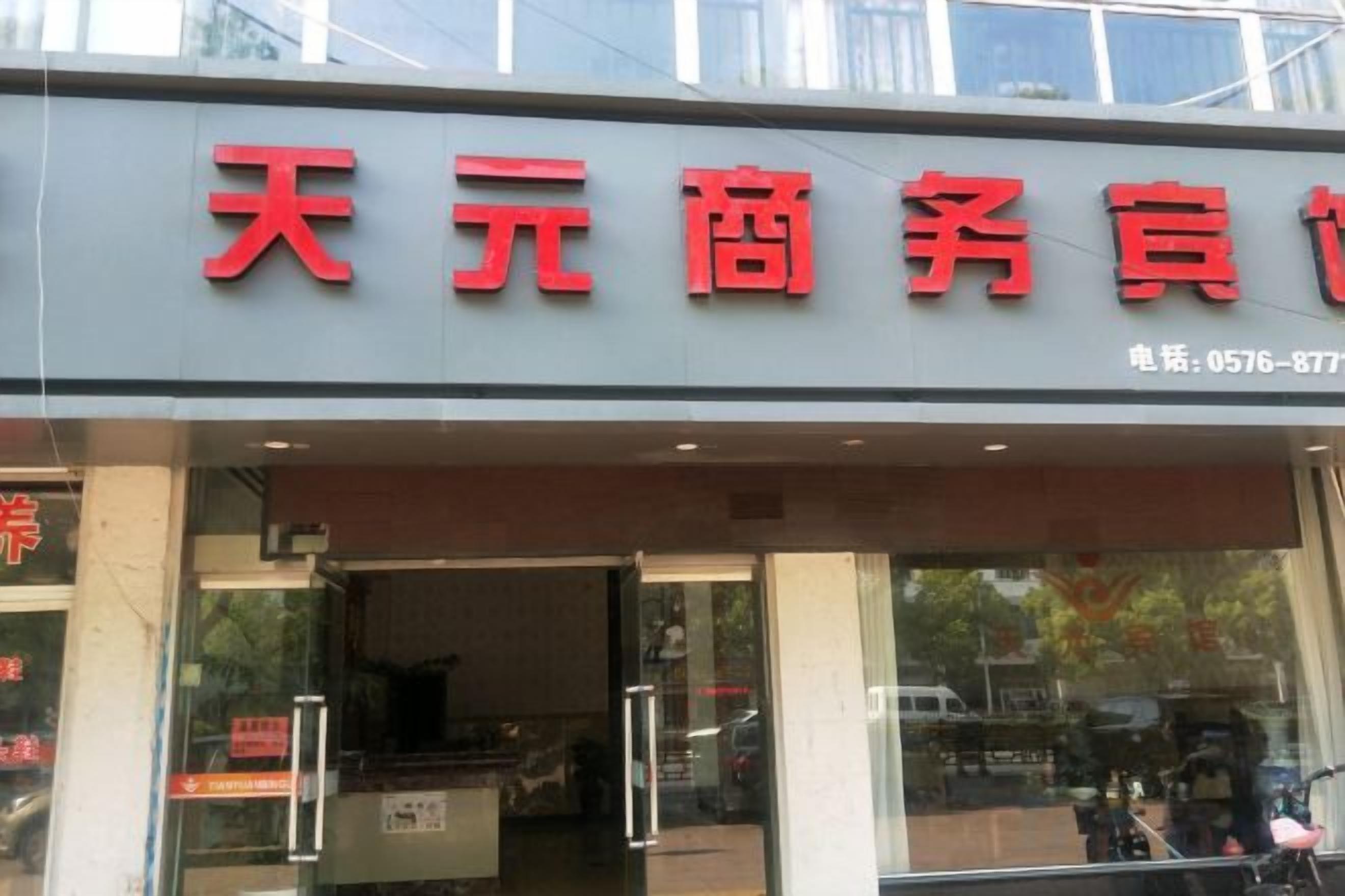 A storefront with large red signage and a contact number.