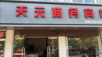 A storefront with large red signage and a contact number.