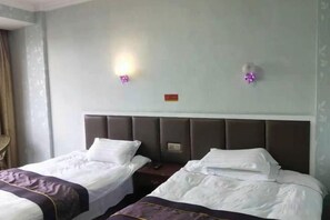A hotel room with two beds, a headboard, and a wall-mounted light fixture. - Xianju Tianyuan Hotel (Xianju)