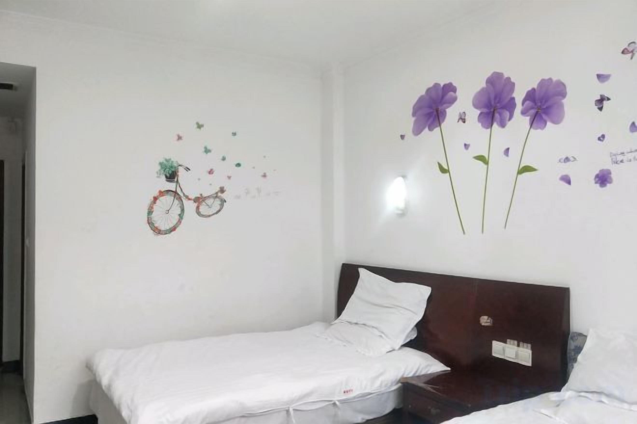 Una cama individual con cabecera de madera en una habitación con paredes blancas.