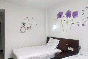 Una cama individual con cabecera de madera en una habitación con paredes blancas.