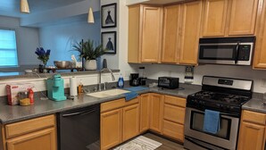 Una cocina moderna con armarios de madera, electrodomésticos de acero inoxidable y encimera de granito.