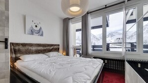 A hotel room with a bed, a view of snow-covered mountains, a radiator, and a painting of a polar bear. - 2nd floor, balcony, tv, ski locker, 41m², Tignes (Tignes)
