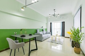 Een moderne woonkamer met een eethoek, een bank, een salontafel en een kamerplant.