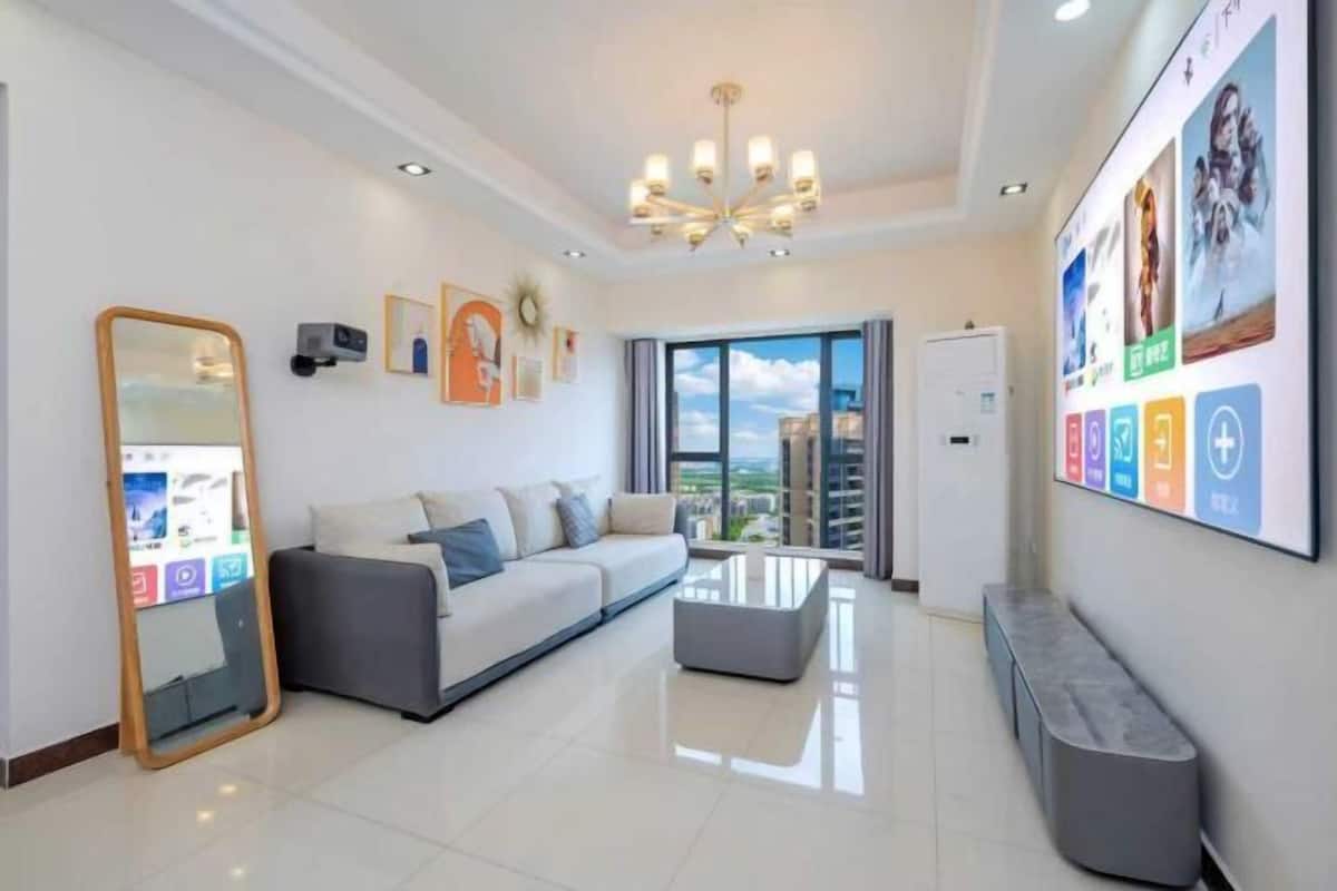 Uma sala de estar moderna com um sofá, uma mesa de centro, um espelho grande e um candelabro.