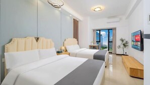 Une chambre d’hôtel avec deux lits, une grande fenêtre et une vue sur l’extérieur.
