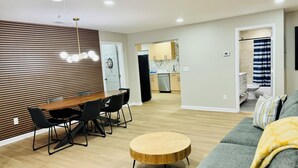 A modern living room with a dining area, a round coffee table, and a gray sofa. - Modern Brick Ranch Retreat NEW Renovation (Mableton)