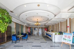A hotel lobby with a reception desk, seating area, and a chandelier. - Dilang Holiday Hotel (Yangzhou Jiangdu Passenger Terminal Branch) (Yangzhou)