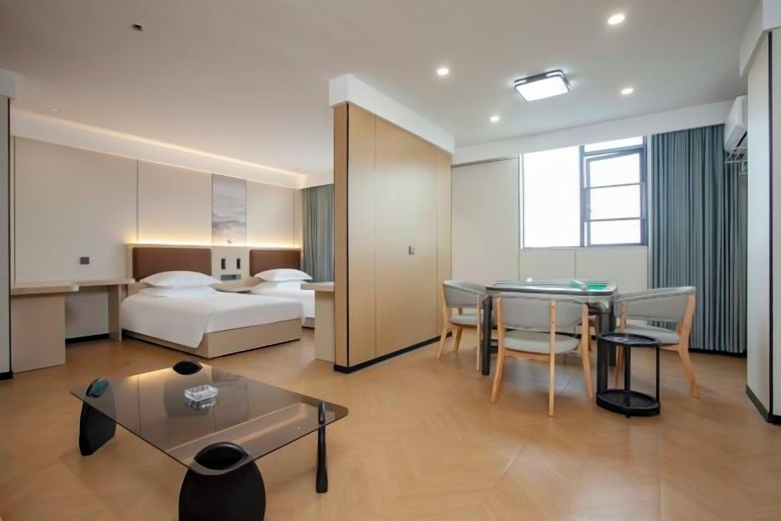 Habitación de hotel moderna con cama, escritorio, silla, una mesita y una ventana.