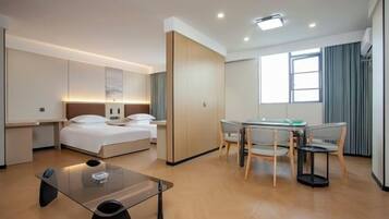 Habitación de hotel moderna con cama, escritorio, silla, una mesita y una ventana.