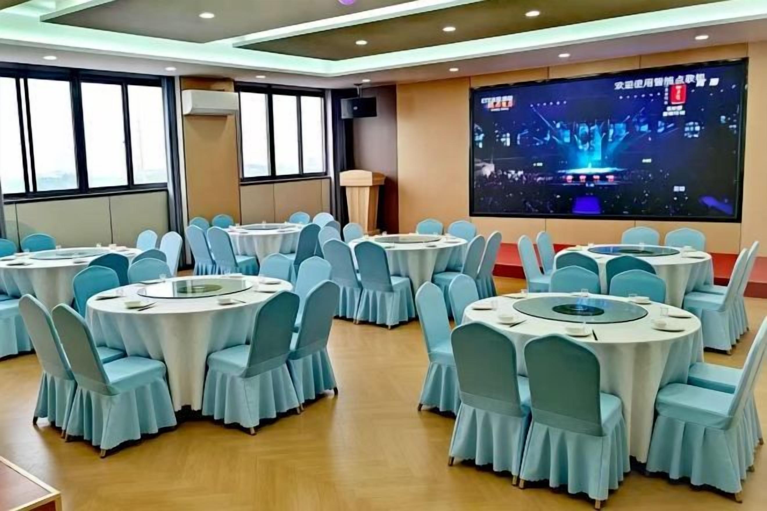 A conference room with multiple round tables, each surrounded by chairs.