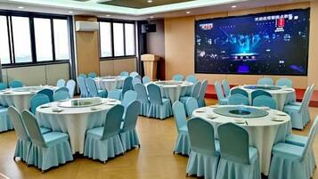 A conference room with multiple round tables, each surrounded by chairs.