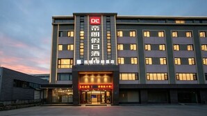 A hotel with a modern facade, multiple floors, and illuminated signage. - Dilang Holiday Hotel (Yangzhou Jiangdu Passenger Terminal Branch) (Yangzhou)