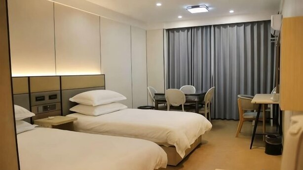 A hotel room with two beds, a desk, and a chair. - Dilang Holiday Hotel (Yangzhou Jiangdu Passenger Terminal Branch) (Yangzhou)