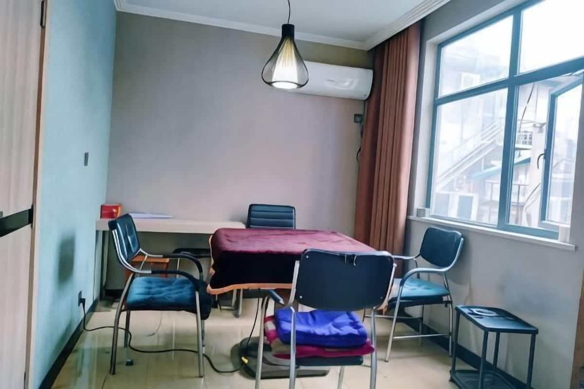 Ein Zimmer mit Tisch, Stühlen, einer Klimaanlage, einem Fenster mit Blick und einer Hängelampe.