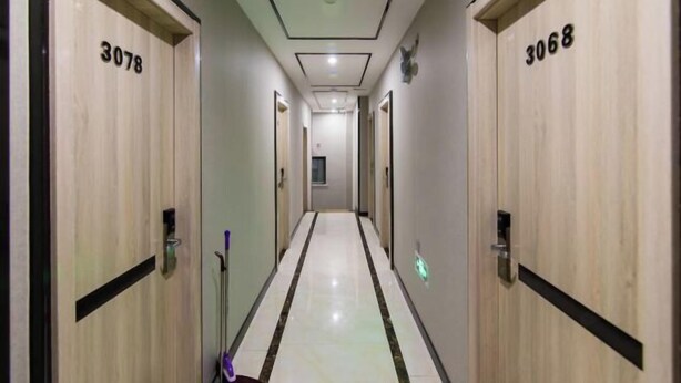 A corridor with wooden doors numbered 3078 and 3068, leading to a room with a window. - Nanyang Yuyu Inn (Nanyang)