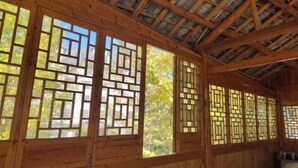 A room with wooden walls and a sloped ceiling with exposed beams. - Lichuan Chunhuiyuan Homestay (Lichuan)