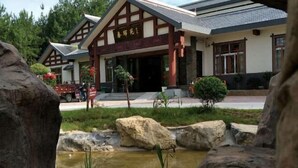 A traditional building with a wooden facade and a stone entrance. - Lichuan Chunhuiyuan Homestay (Lichuan)