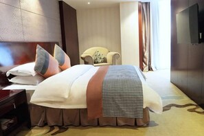 A hotel room with a large bed, a chair, a TV, and a window with curtains. - Mingdu Hoki International Hotel (Changzhou)