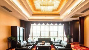 A hotel lobby with a red carpet, leather sofas, a chandelier, and large windows. - Mingdu Hoki International Hotel (Changzhou)