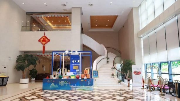 A spacious lobby with a tiled floor, a staircase, and a vending machine. - Mingdu Hoki International Hotel (Changzhou)