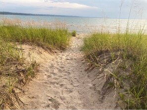 A sandy beach path with grass on either side leading to the water. - Rustic 5-bedroom cottage with private beach near Harbor Springs  (Harbor Springs)