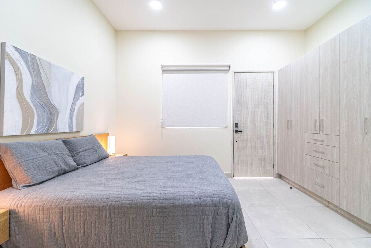 Une chambre à coucher avec un lit, une armoire et une porte avec une fenêtre.