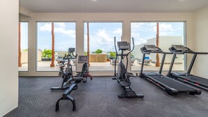A gym with treadmills, stationary bikes, and an elliptical machine.
