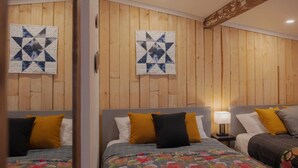 A room with two beds, wooden panel walls, and quilts on the beds. - Jaune Hôtel Boutique (Saint-Gédéon)