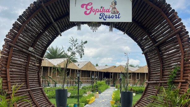 Entrada de un resort con un arco de bambú y un letrero que dice 'Gonokoi Resort'.