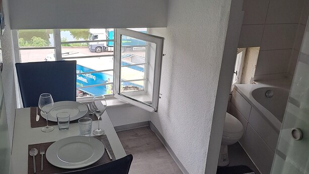 Cocina compacta con comedor, vistas al exterior y un baño pequeño.