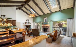 A spacious living area with a fireplace, wooden furniture, and a view of the outdoors.