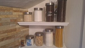 A shelf with various containers, including jars and bottles, likely used for storage or decoration. - Modernes Apartment in Minden am Hauptbahnhof (Minden)