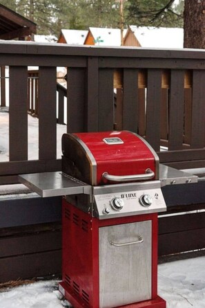 Una barbacoa daurada i platejada per a l'exterior, amb un panell de control, situada sobre una superfície metàl·lica.