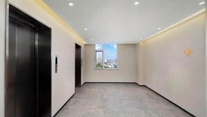 A modern hallway with a view to the outside, a door, and a small window. - Jinjiang Inn Hotel (Zhengzhou Ocean Park Wenhua Road Branch) (Zhengzhou)