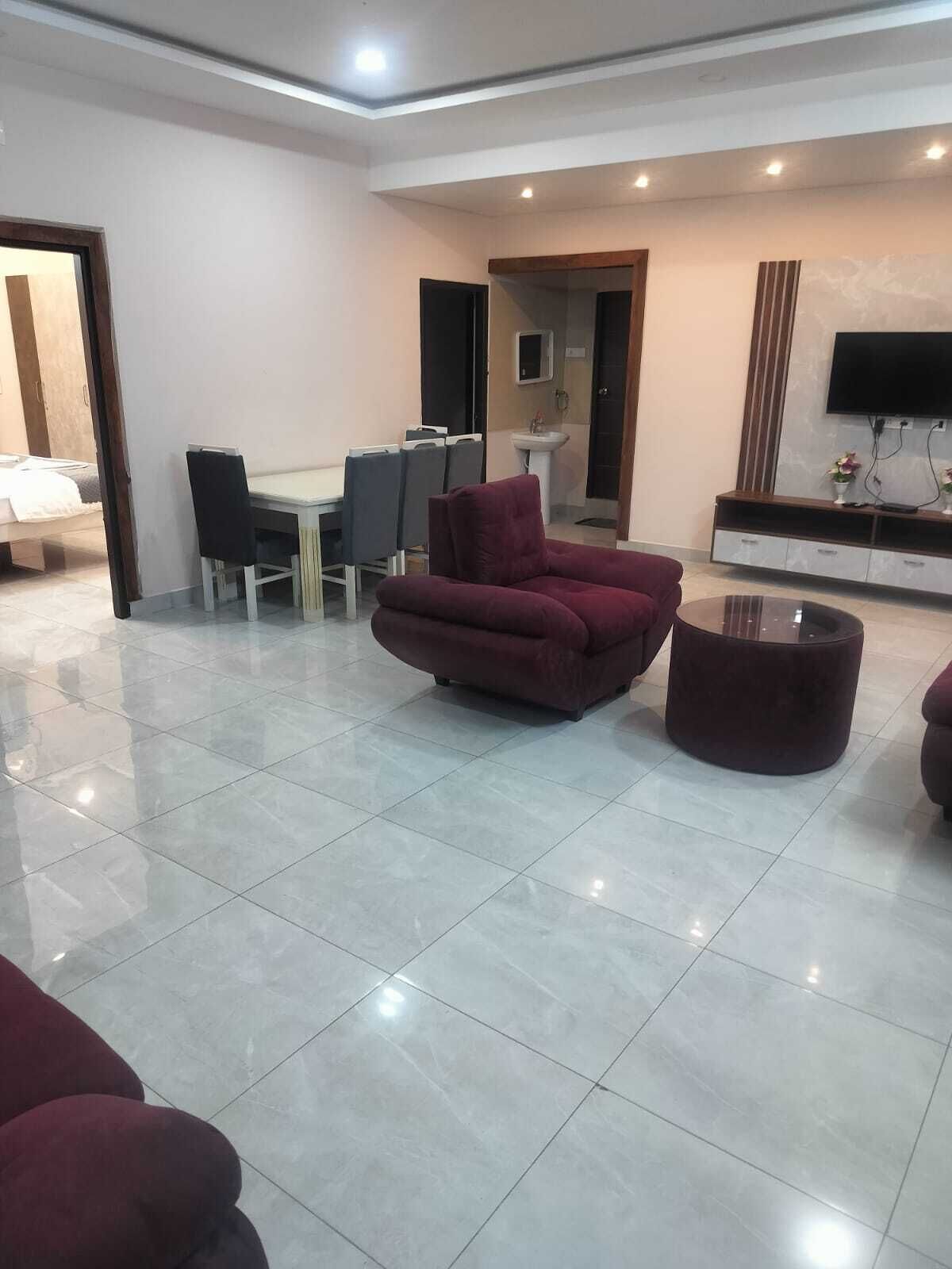Una sala de estar amplia con un sofá grande, una mesa de centro y un comedor con sillas y una mesa.