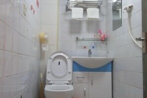 A bathroom with a toilet, sink, and mirror. - Longyan Jinyuan Hotel (Longyan)