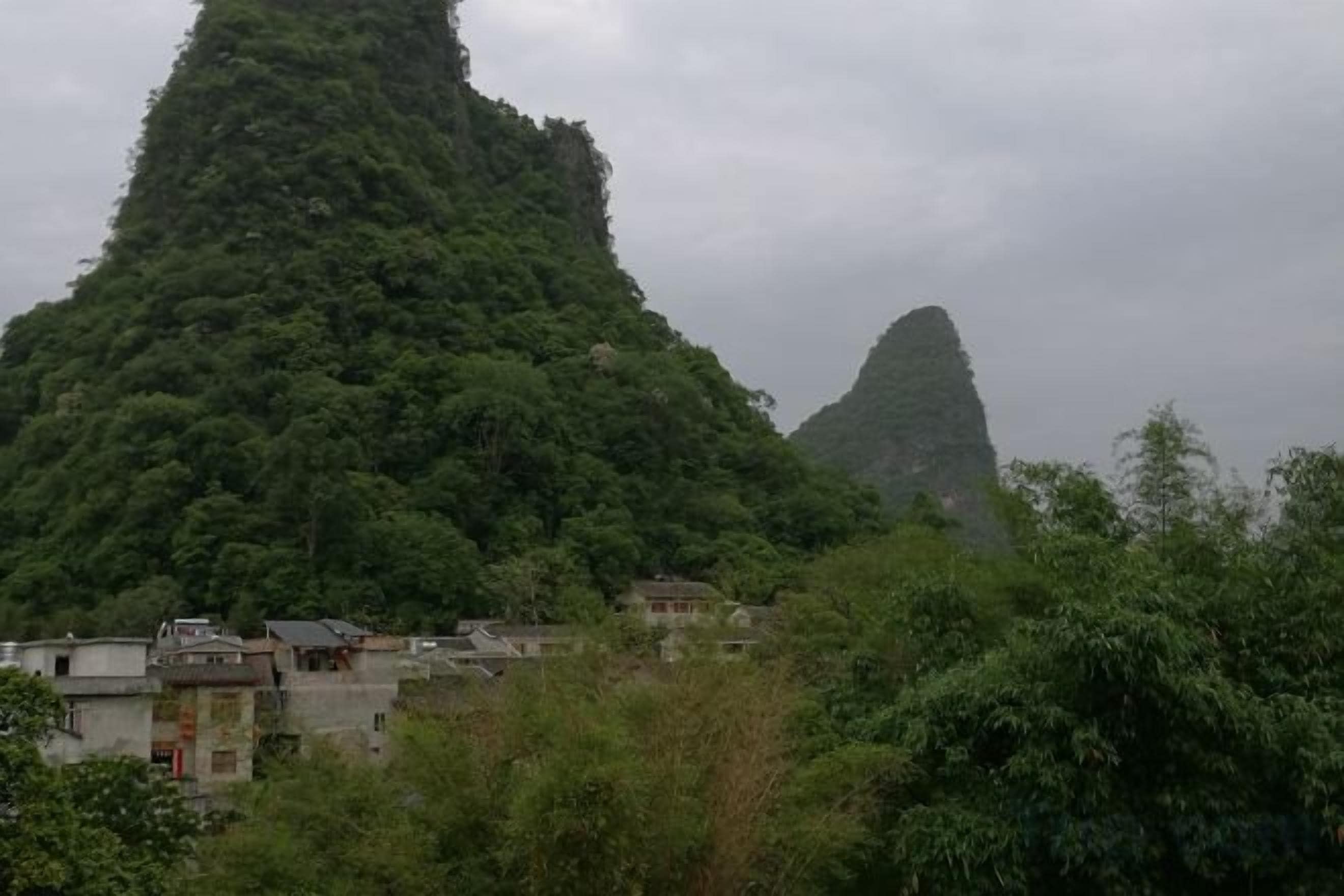 Eine Berglandschaft mit einem Dorf im Vordergrund.