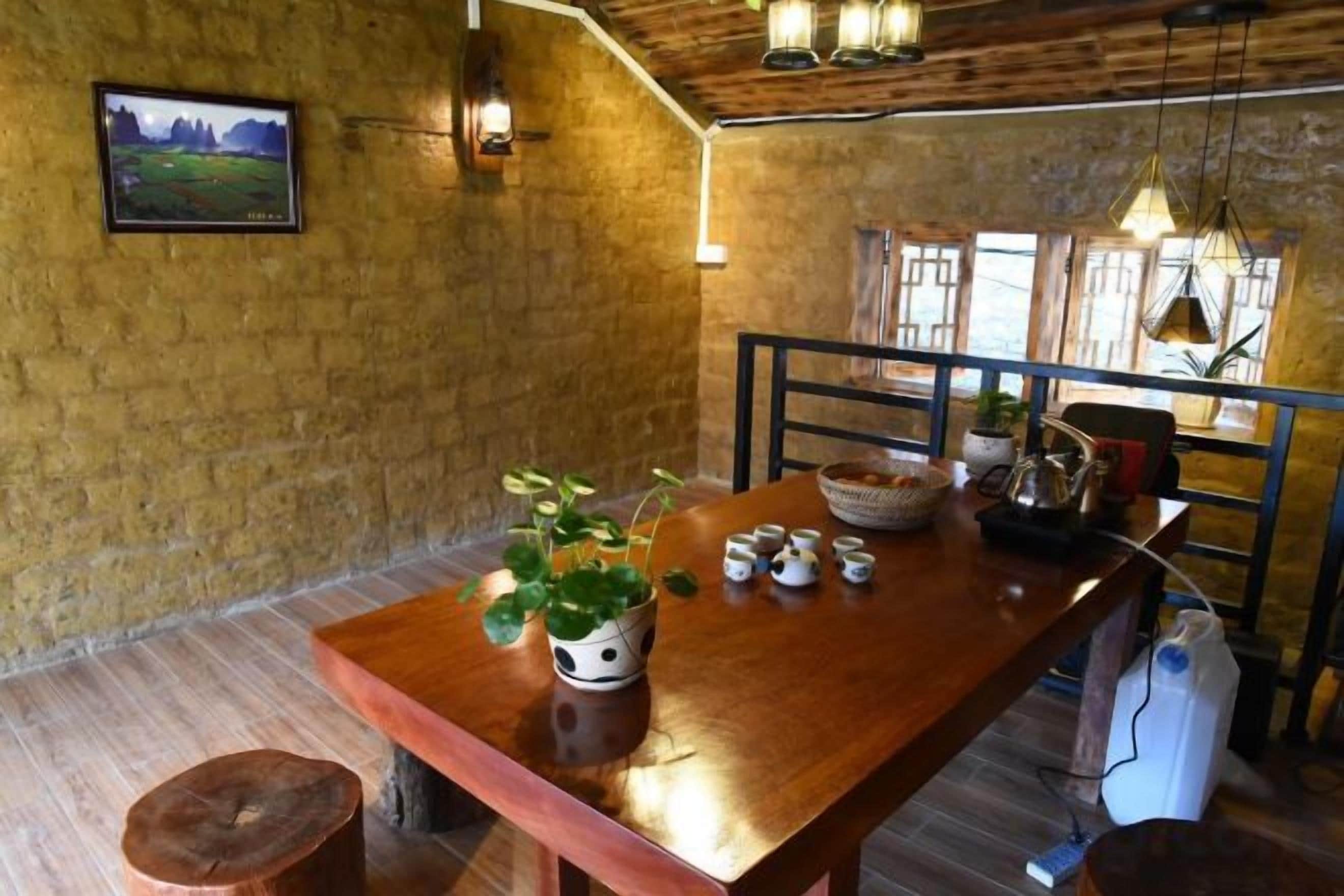 A rustic dining area with a wooden table, chairs, a bowl, and a potted plant.