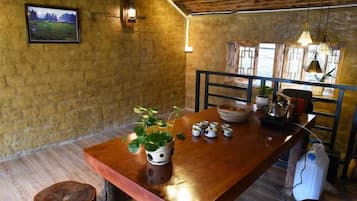 Un comedor rústico con una mesa de madera, sillas, un cuenco y una planta en maceta.