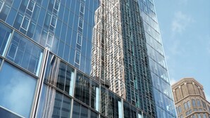 Un gratte-ciel moderne doté d’une façade en verre réfléchissant et d’une flèche centrale.
