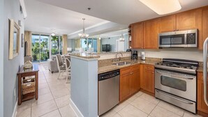 Una cocina moderna con encimeras de granito, electrodomésticos de acero inoxidable y armarios de madera.