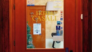 Una porta di camera d'albergo con stipite in legno, un pannello di vetro e una serratura.