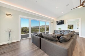 Relax in this stylish living room with a sofa, flat-screen TV, and balcony access.