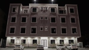 A multi-story building with a symmetrical facade, multiple windows, and a central entrance. - Nma'a Residences (Riyadh)