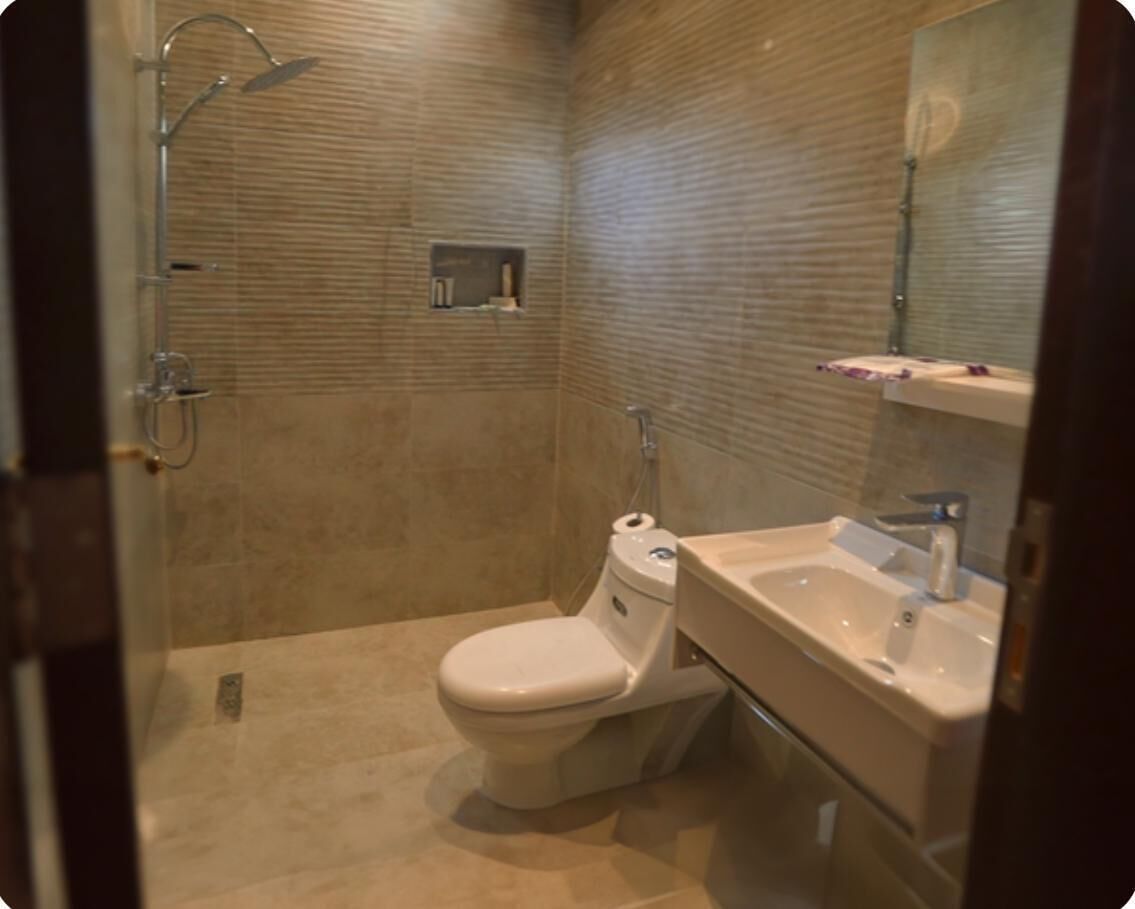A bathroom with a toilet, sink, and shower.