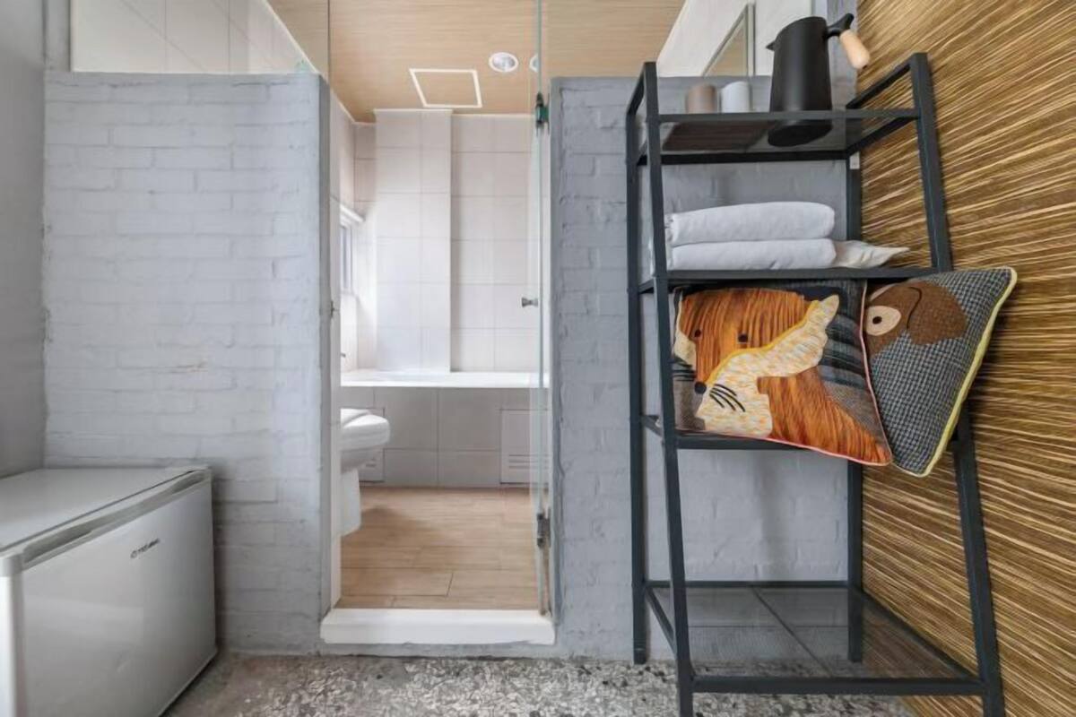 Una cocina compacta con un refrigerador blanco, un lavamanos y una encimera de madera.