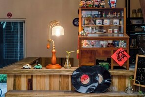 Una mesa de madera con una lámpara antigua, un disco de vinilo y un pequeño coche de juguete.